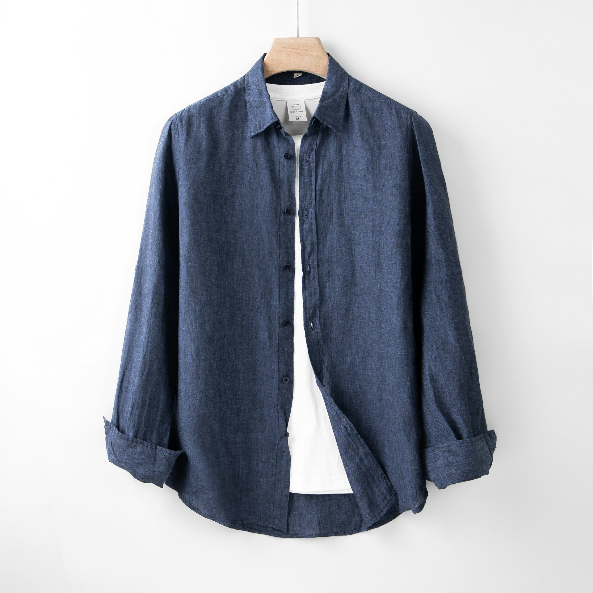 A blue shirt hanging on a white wall